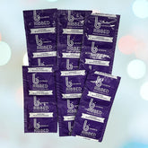 A pastel-colored background showcases seven scattered packages of bCondoms Ribbed Condoms, each marked for ultra stimulation. The purple packages emphasize supporting Black businesses and include the brand's website. These premium condoms are made from natural rubber latex by bCondoms.